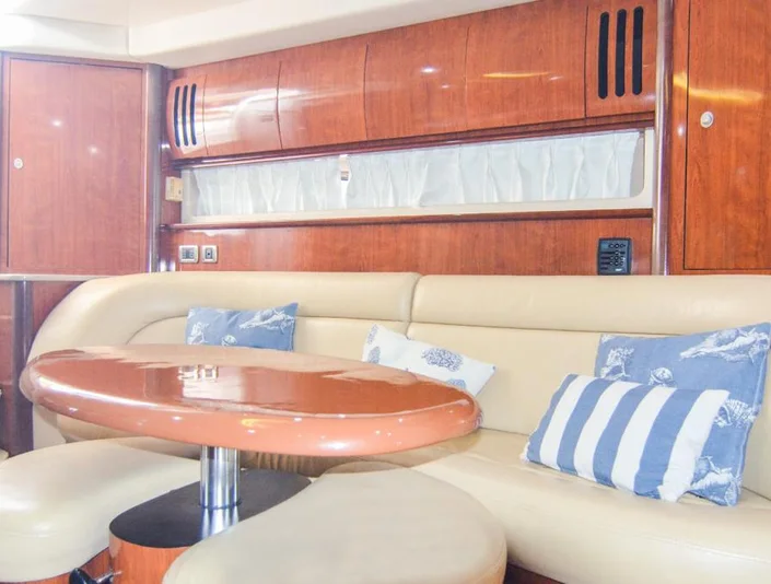 Sea Ray 42 cream dining lounge with wood table and blue cushions