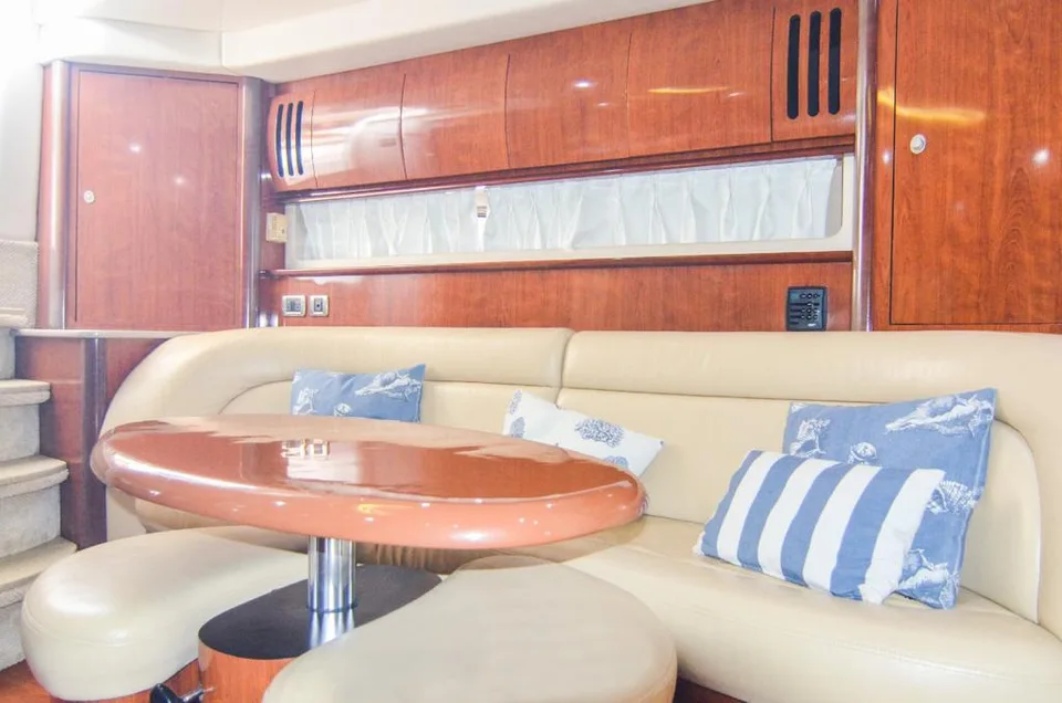 Sea Ray 42 cream dining lounge with wood table and blue cushions